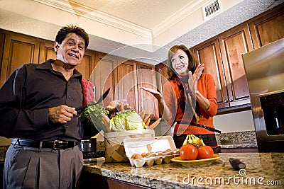 Mature couple having fun cooking in kitchen