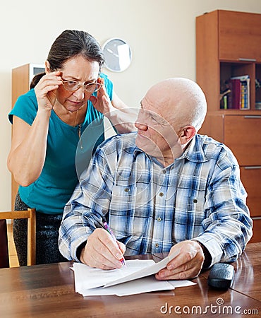 Mature couple reading financial documents