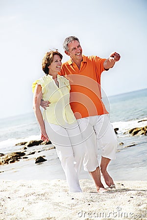 Mature couple walking along the beach.