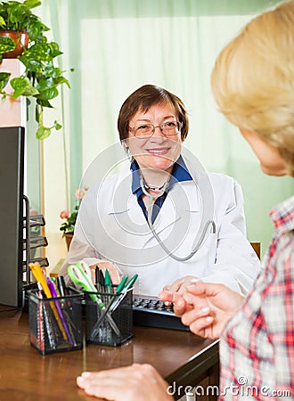 Mature doctor consulting female patient