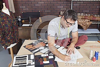 Mature male fashion designer working on sketch in design studio