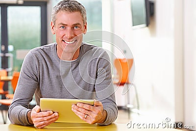 Mature Student Studying In Classroom With Digital Tablet