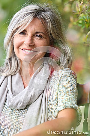 Mature woman with gray hair sitting outdoor
