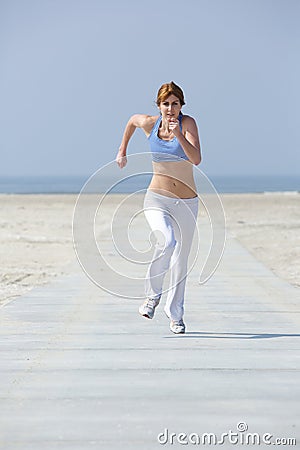 Mature woman jogging at the beach