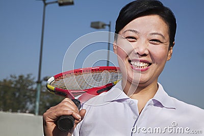 Mature woman playing tennis, portrait