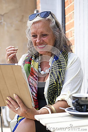 Mature woman unsing mobile device in cafe