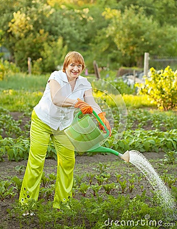 Mature woman watering plant