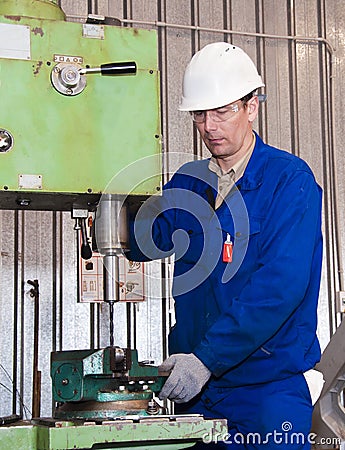 The mechanic dressed in overalls, works at the boring machine