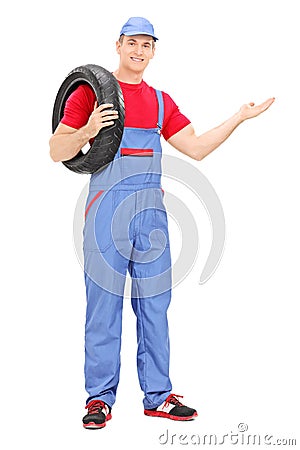 Mechanic holding a tire and gesturing with hand