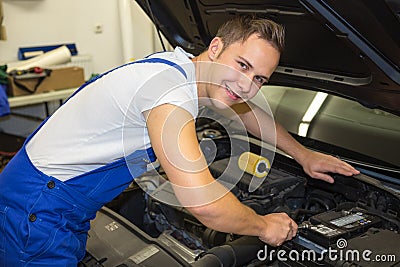 Mechanic with tools in garage repairing the motor of a car