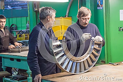 Mechanics assembles turbine for aviation engine