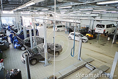 Mechanics repair cars in station for maintenance