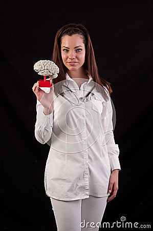 Medic woman holding a human brain model against black background