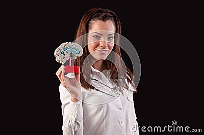Medic woman holding a human brain model against black background