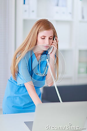 Medical doctor woman with computer and telephone.