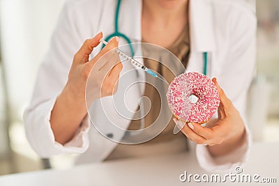 Medical doctor woman making injection into donut