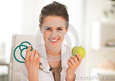 Medical doctor woman showing apple and stethoscope