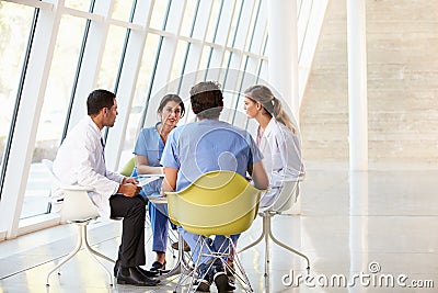 Medical Team Meeting Around Table In Hospital
