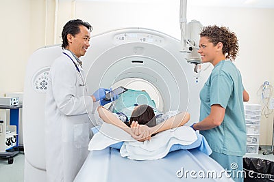 Medical Team With Patient In CT Scan Room