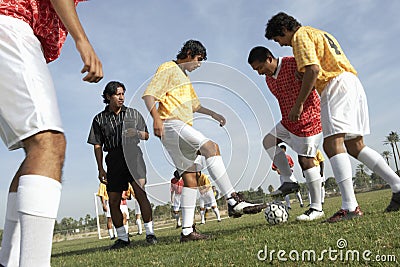 Men Playing Soccer While Referee Watching Them