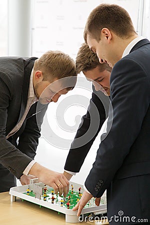 Men plays in football table game