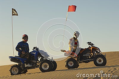 Men Sitting On Quad Bikes In Desert