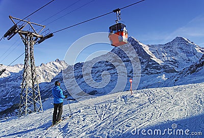 Men on ski near cable railway on winter sport resort in swiss al