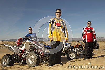 Men Standing By Quad Bikes In Desert