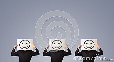 Men in suit gesturing with sketched smiley faces on cardboard