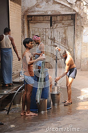 Men washing clothes. Old Delhi, India.