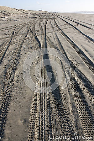 Messy beach sand with tyre tracks