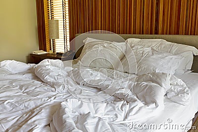 Messy white bed and two pillow