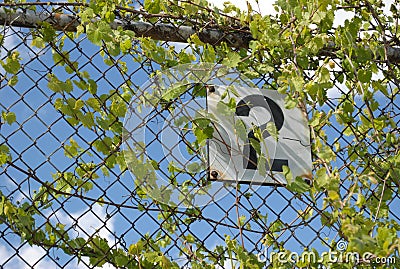 Metal sign on a fence.