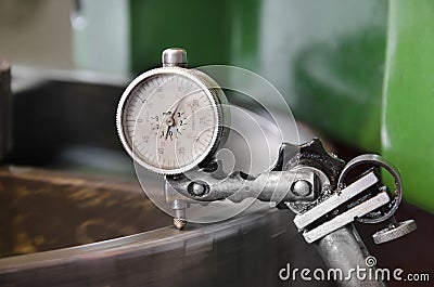 Metal workshop machine, dial gauge instrument measures inclination of cogwheel gear