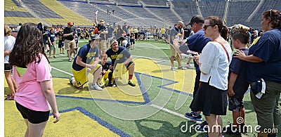 Michigan football fans take photos on the field