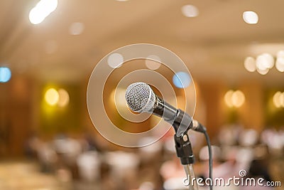 Microphone in concert hall or conference room with lights in bac