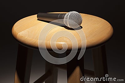 Microphone Laying on Wooden Stool Under Spotlight Abstract.