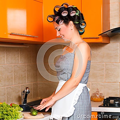 Middle-age beautiful woman in the kitchen with knife