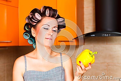 Middle-aged woman housewife in kitchen looking with disgust at pepper