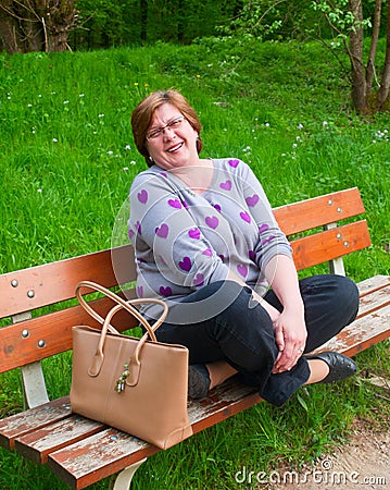 Middle-aged woman relaxing on a park bench