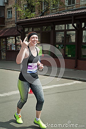 Middle aged woman runner smiling and saluting