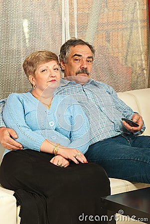 Middleaged couple watching tv home