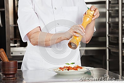 Female Chef With Peppermill Seasoning Dish