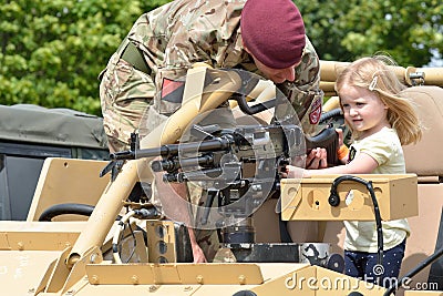 Military Tattoo COLCHESTER ESSEX UK 8 July 2014: Small Girl being shown gun