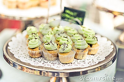 Mini cupcakes with green icing on a silver tray