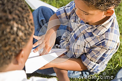 Mixed Race Father and Son Playing Paper Airplanes