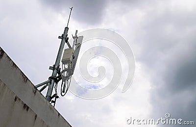 Mobile phone transmitter antenna on sky with many clouds