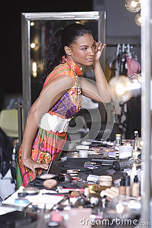 Model Applying Makeup In Dressing Room Mirror
