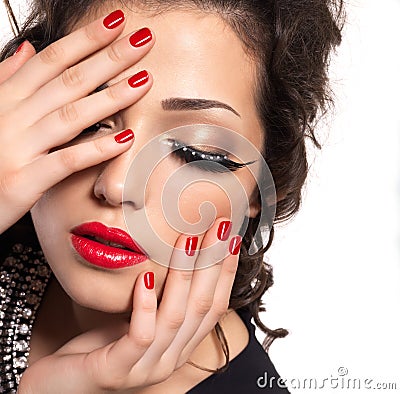 Model with red nails, lips and creative eye makeup