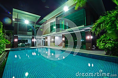 Modern house with swimming pool at night